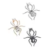 Three vintage crystal spider brooches, silver, gold and black alloy pins, Muslim-style white display stand undefined